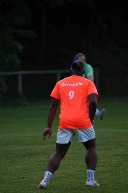 Number 9 in orange waits for the play at Germania at dusk, June 2025