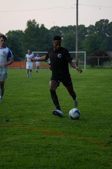 A player in black drives down the wing with the ball, June 2025