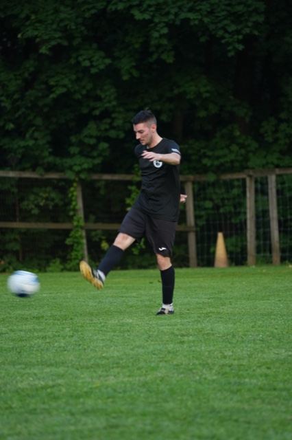 A player in black strikes a long pass, June 2025