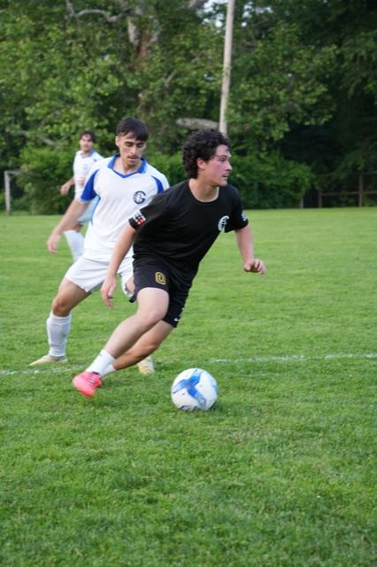 A player in black cuts inside past a defender in white, June 2025