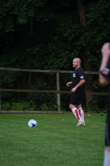 A player in black tracks the ball across the grass at Germania, June 2025